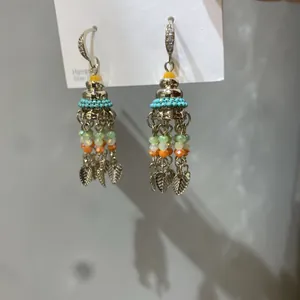 Close-up detail of Bohemian style tassel earrings with colorful glass beads and silver leaf charms