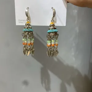 Detailed shot of retro Bohemian earrings featuring colorful beads and leaf tassels