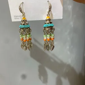 Detail view of Bohemian style drop earrings with zircon hooks and leaf tassel charms