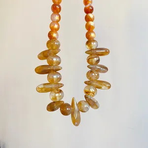 Detailed view of the marbled orange acrylic beads on this statement irregular oval necklace