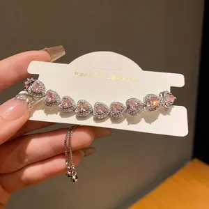 Close-up of elegant silver-tone bracelet with sparkling pink heart-shaped zircon stones