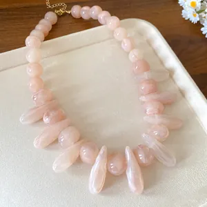 Close-up detail of pink marbled acrylic necklace featuring irregular oval and drop beads