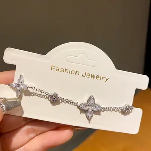 Close-up detail showing sparkling silver zircon flower bracelet on a white card