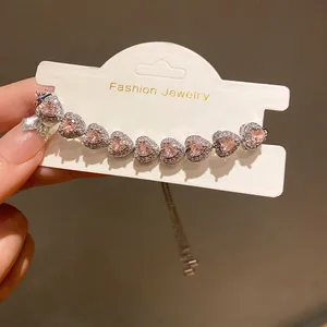 Detailed view of pink heart zircon bracelet with sparkling accents on display card
