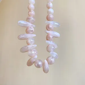 Detailed view of pink marbled acrylic beads on an irregular statement necklace