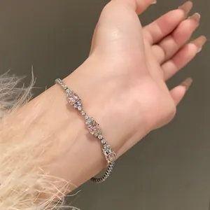 Elegant zircon bracelet with pink square crystals shown on a female wrist.