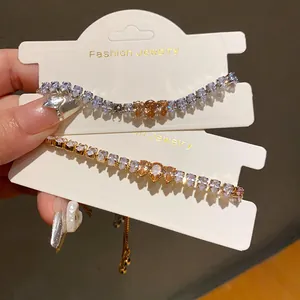 Detail of gold and silver Korean style bracelets with pear-cut sparkling zircons