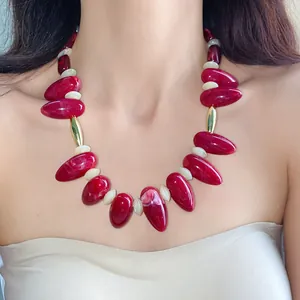 Chunky burgundy acrylic oval necklace with gold accents on an Asian model's neck