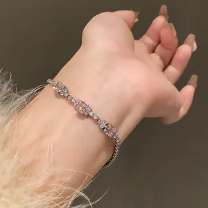 Close-up view of an elegant pink zircon spliced bracelet worn on a wrist with a fuzzy sleeve