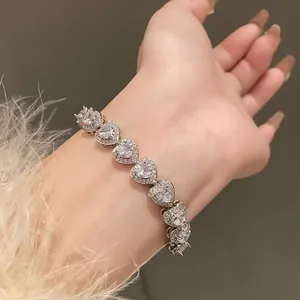 Close-up detail of a silver heart-shaped zircon bracelet worn on a female wrist
