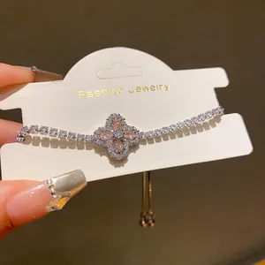 Macro view of sparkly zircon flower bracelet with pink stones on a display card.