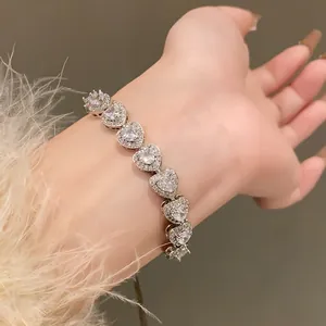 Close-up of heart-shaped zircon bracelet on wrist with elegant fluffy sleeve detail.