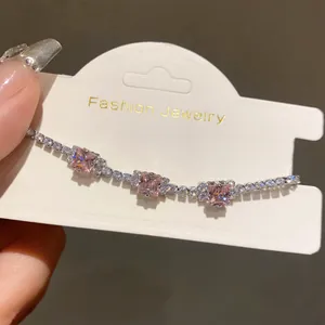 Detail shot of a silver bracelet featuring square pink stones and clear zircon accents.