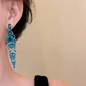 Primo piano di squisiti orecchini vintage a goccia stile palazzo con eleganti strass blu mare