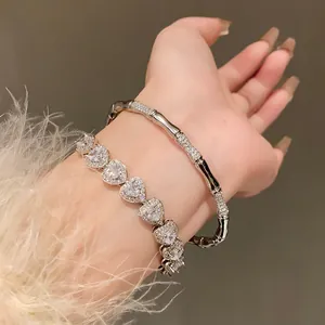 Elegant close-up of heart zircon bracelet and silver bamboo-style bangle on wrist