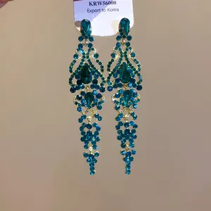 Dettaglio di orecchini vintage dorati con cristalli blu e nappe a goccia d'acqua.