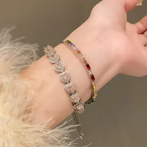 Close-up of heart-shaped pink zircon bracelet and multi-colored gemstone hand jewelry