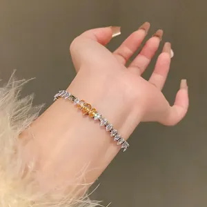 Detailed view of a sparkling zircon bracelet with heart-shaped yellow stones on a wrist