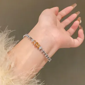 Detailed view of shimmering zircon heart and teardrop stones on a slender bracelet