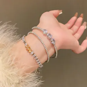 Detailed view of stacked zircon bracelets with heart and oval cut stones on a wrist