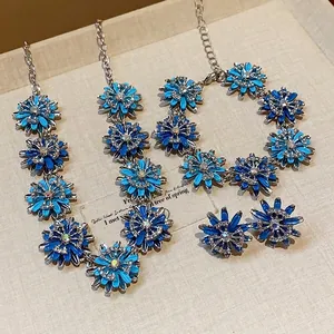 Blue flower jewelry set with necklaces and earrings on a vintage display board.