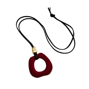 Vintage red velvet flocked circular pendant necklace with black cord and gold bead accent