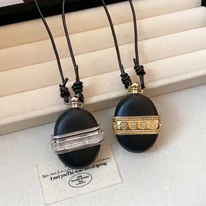 Collier vintage en cuir avec d'élégants pendentifs ovales en zircon en or et argent.