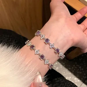 Détail du bracelet coréen en zircon fleur sur le poignet avec des cristaux violets