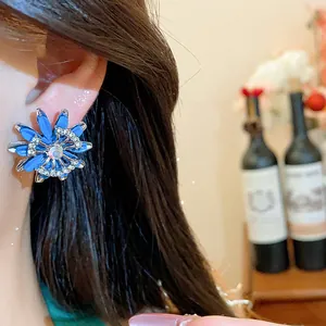 Detailed view of a vintage style blue flower stud earring featuring sparkling rhinestones