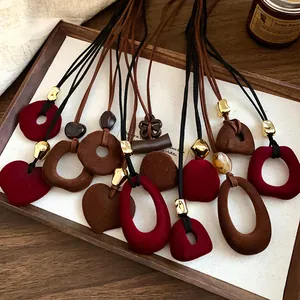 Collection of retro velvet flocked heart and geometric pendant necklaces on wooden tray