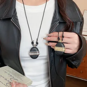 Détail du collier sautoir rétro avec pendentif médaillon noir mat et zircons sur modèle