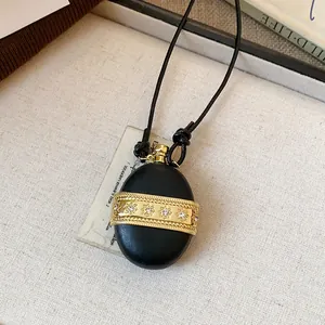 Vue détaillée d'un collier pendentif noir rétro orné d'une bande de zircon doré poli