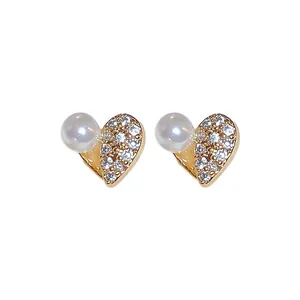 Eleganti orecchini a lobo a forma di cuore con zirconi e perle su sfondo bianco puro