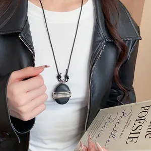 Élégant collier vintage en cuir noir avec un pendentif en pierre ronde sur un mannequin