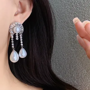 Dettaglio di orecchini vintage in argento con perle a goccia e cristalli brillanti