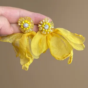 Close-up of yellow chiffon flower tassel earrings with sparkling zircon centers.