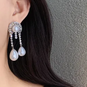 Eleganti orecchini a goccia in tonalità argento con strass e perle sintetiche lucide.