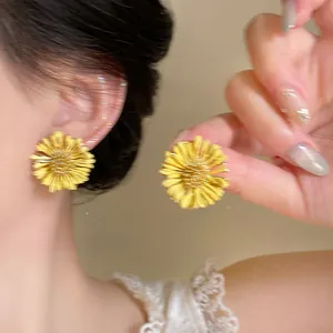 Close-up of yellow chiffon flower earrings with mesh texture and sparkling zircon center