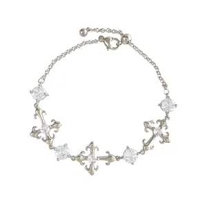 Elegant silver cross bracelet with sparkling cubic zirconia and fleur-de-lis motifs, adjustable