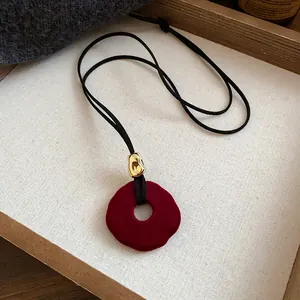 Detailed view of vintage burgundy velvet flower pendant necklace with golden bead accent