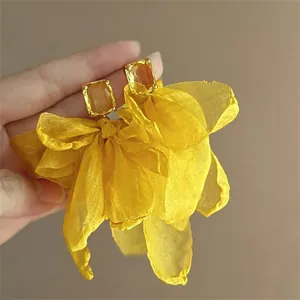 Detailed view of elegant vibrant yellow chiffon flower tassel earrings with amber zircon