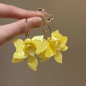 Macro detail of elegant yellow flower hoop earrings with realistic textured petals