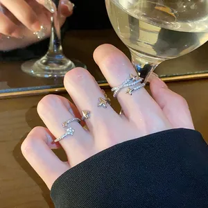 Close-up of star-shaped zircon open rings on fingers in an elegant lifestyle setting