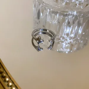 Close-up of elegant silver star open ring showing exquisite metal texture on mirror background