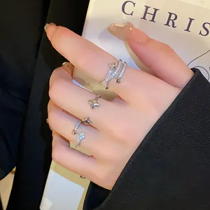 Close-up of adjustable silver-toned open rings featuring zircon-studded star designs