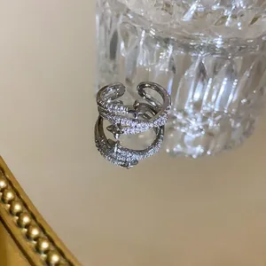 Detailed view of silver-tone pave zircon star open ring reflecting on a mirror surface