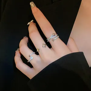 Detailed macro shot of sparkling star-shaped silver zircon open rings on woman fingers