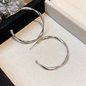 Elegant silver-toned twisted hoop earrings with a minimalist metallic texture