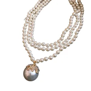 Elegante collana di perle multistrato in stile francese con un grande ciondolo di strass.