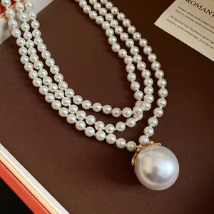 Dettaglio di una collana di perle vintage francese a tre strati con un grande pendente